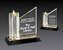 Clear acrylic engraving plaque with a star shapped tower beside it, all set on black gold mirrored base