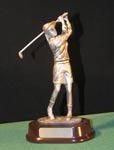 This is a image of a silver colored resin female golfer in a back swing set on a dark red oval base